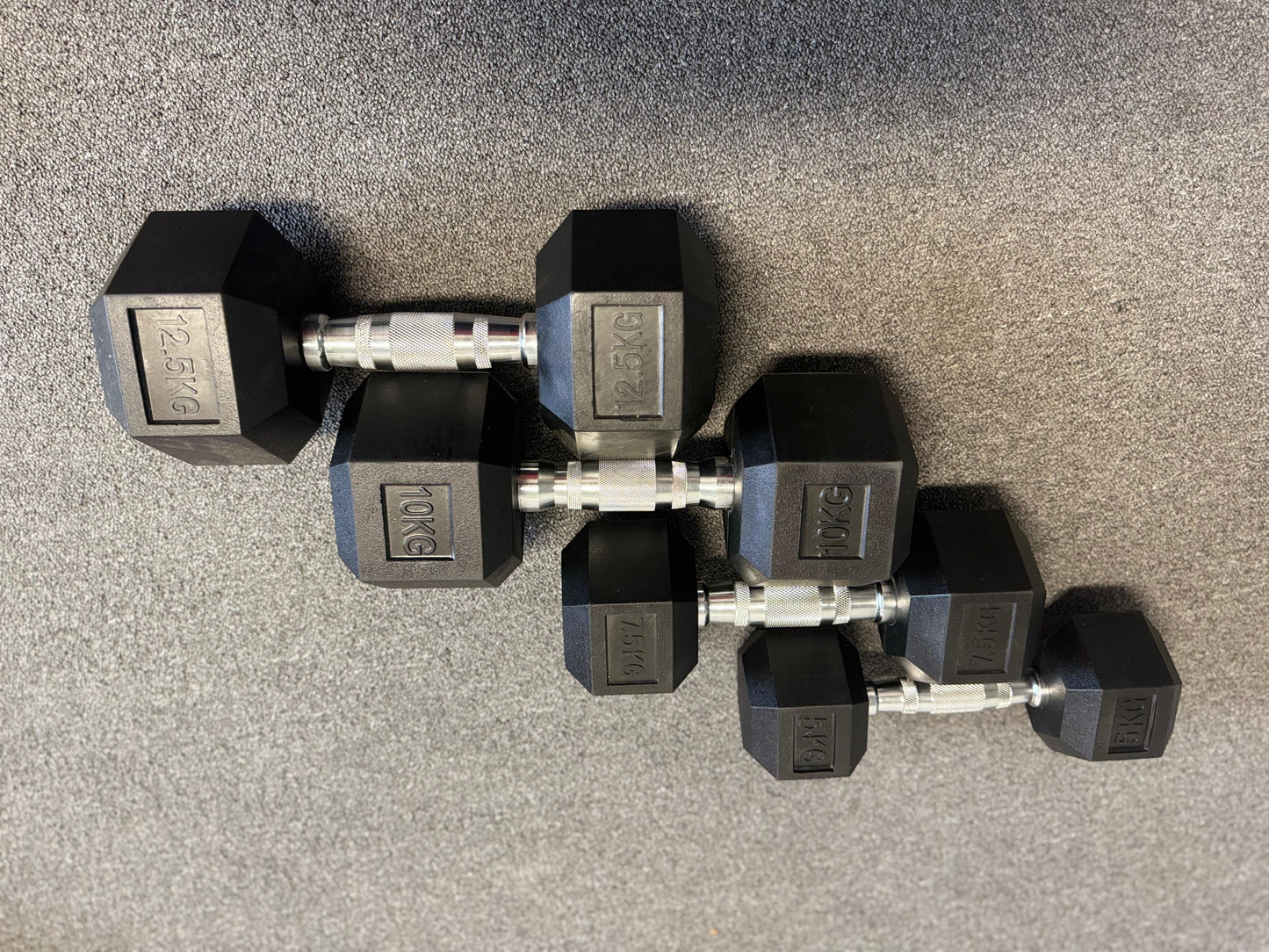 Pair of hexagonal dumbbells on a gray surface
