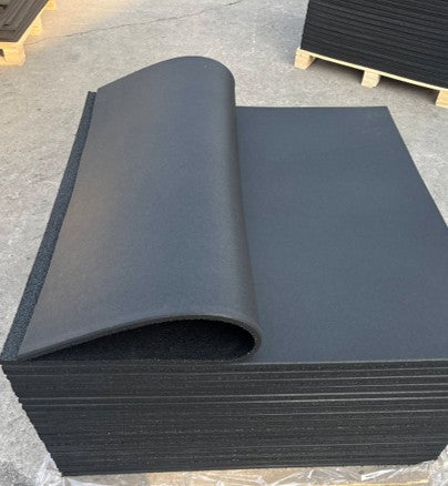 Stack of black rubber sheets on a concrete floor