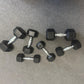 Set of black hexagonal dumbbells on a gray floor