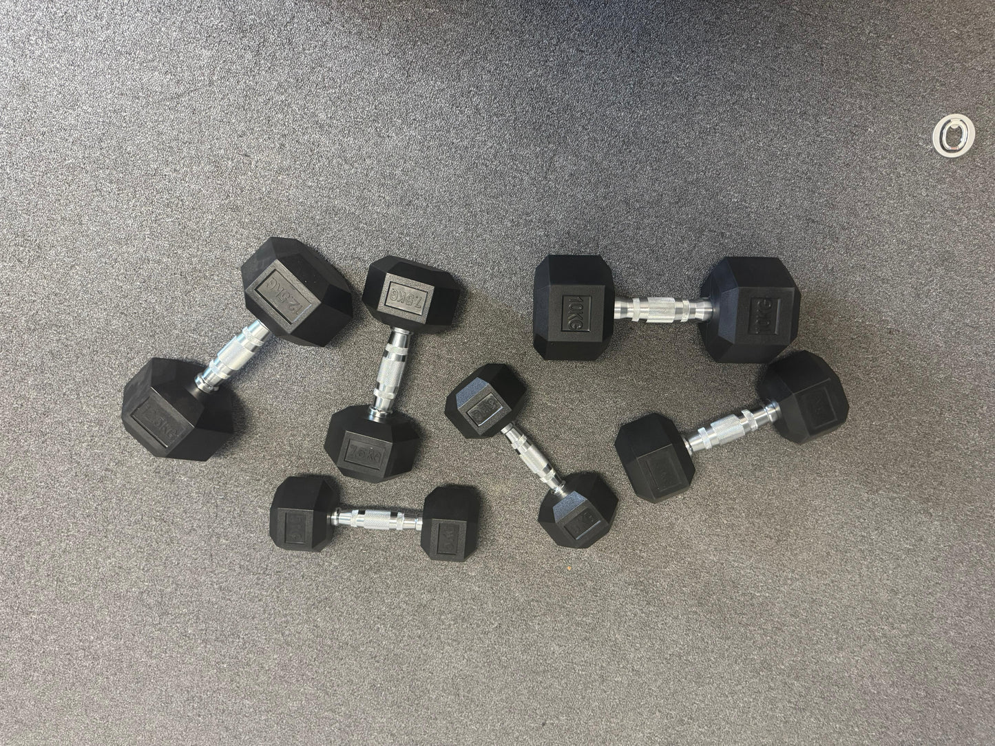 Set of black hexagonal dumbbells on a gray floor