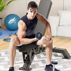 Man exercising with dumbbells on a weight bench in a home setting